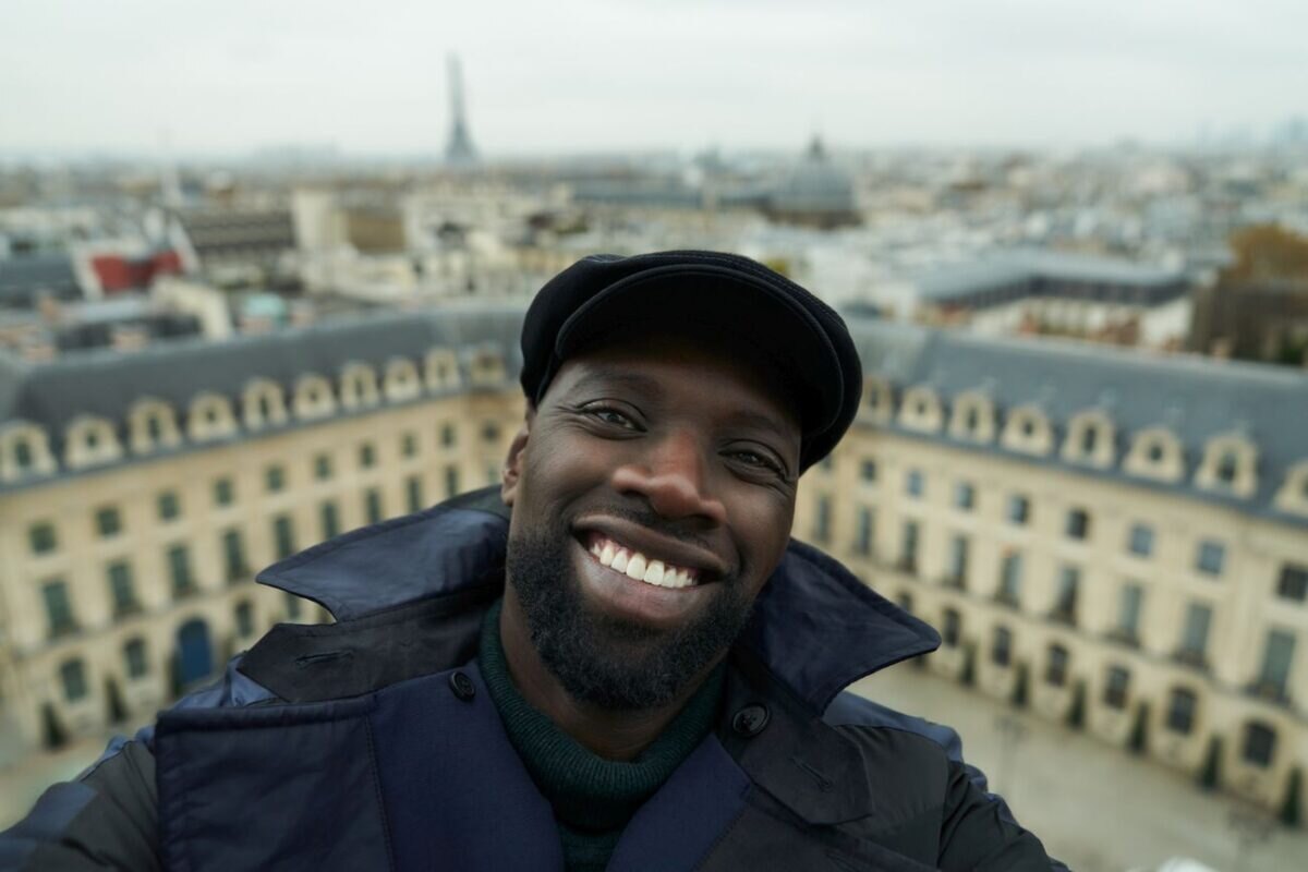 Usmívající se Omar Sy jako Assane Diop v Paříži. Třetí řada seriálu Luipin.