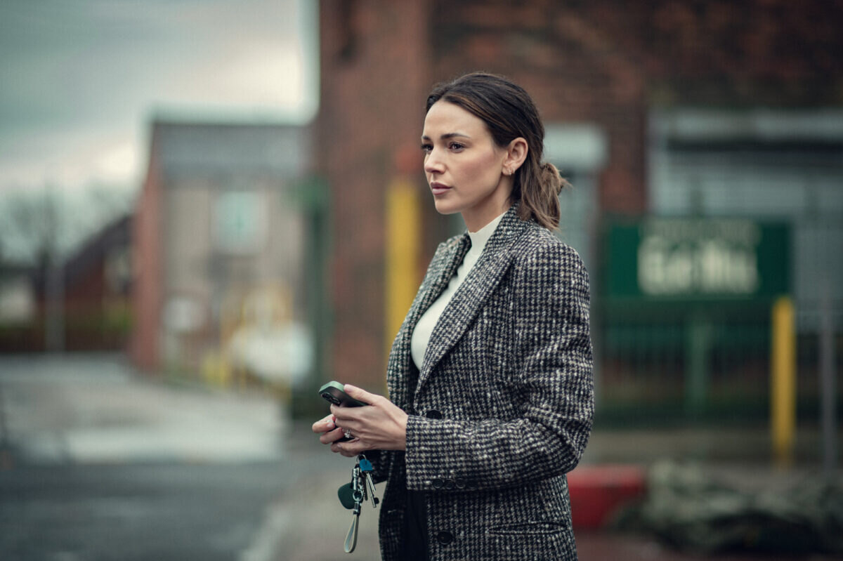 Michelle Keegan stojí na ulici a v ruce drží telefon a klíče - v seriálu Fool Me Once podle knihy Harlana Cobena.
