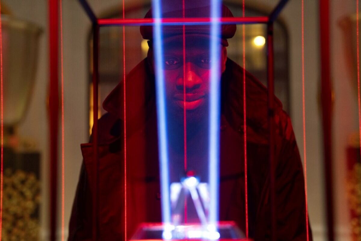 Omar Sy skrze laserové paprsky sleduje černou perlu, kterou chce urkrást. V seriálu Lupin.